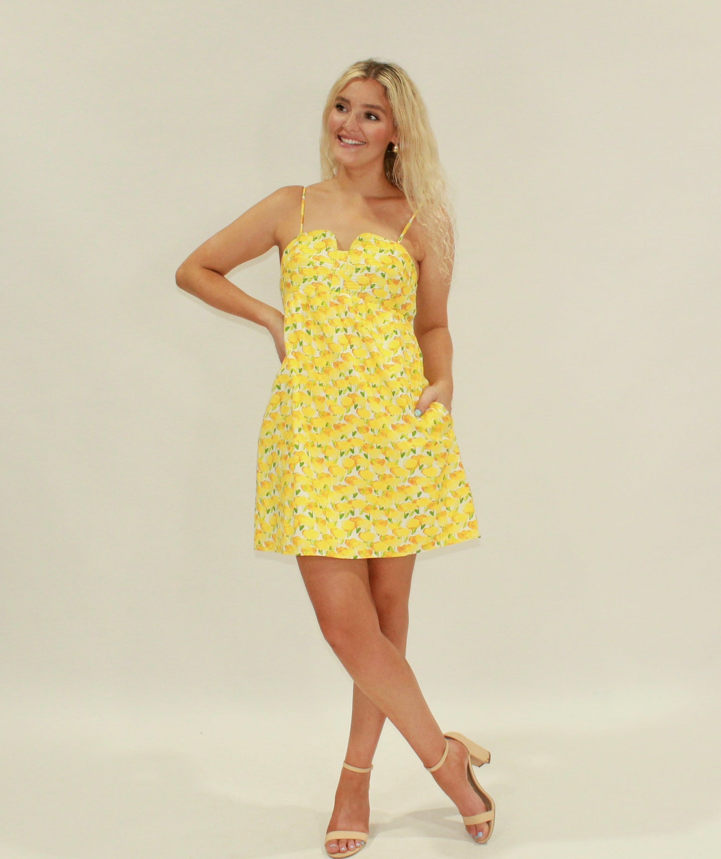 Yellow lemon print sundress with adjustable straps and pockets, perfect for summer outings.