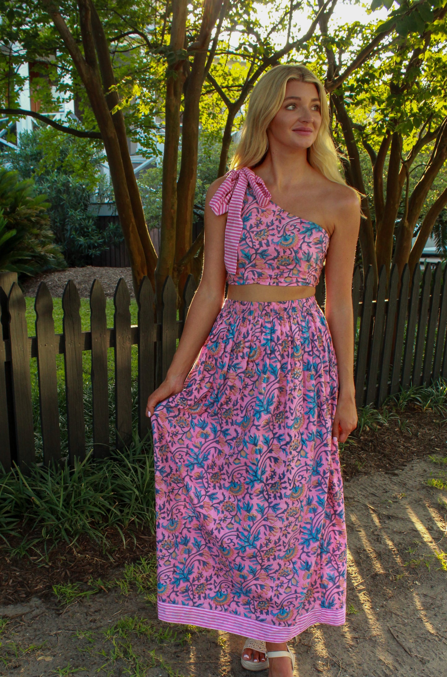 One-shoulder pink floral two-piece set with striped detailing, perfect for summer outings.