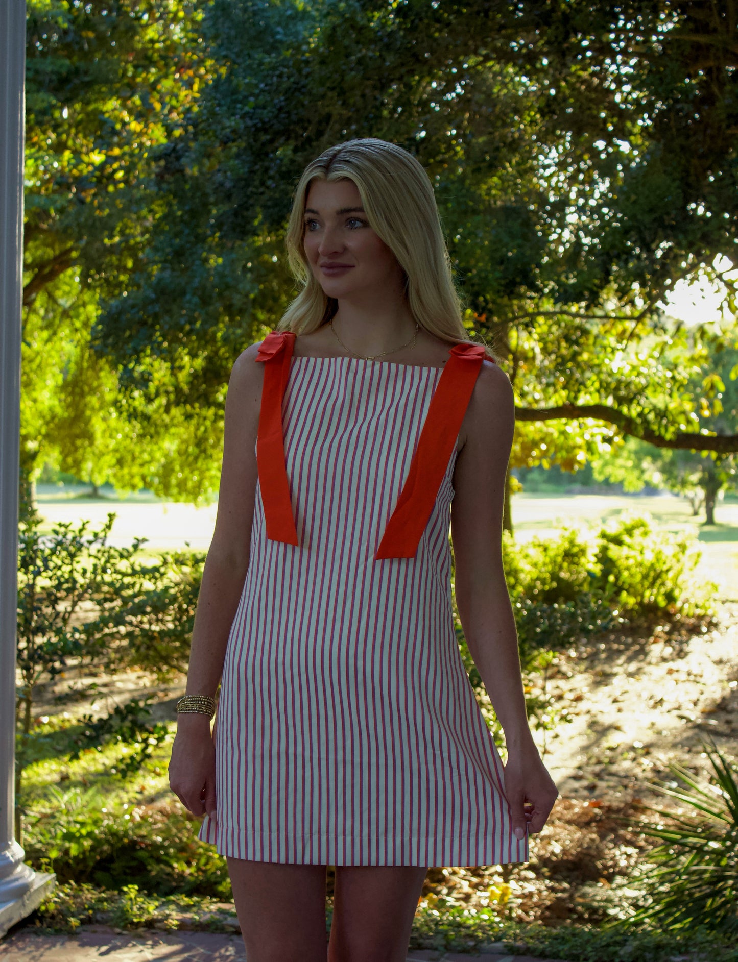 Women’s striped mini dress with orange bows, lightweight cotton fabric, perfect for summer outings.