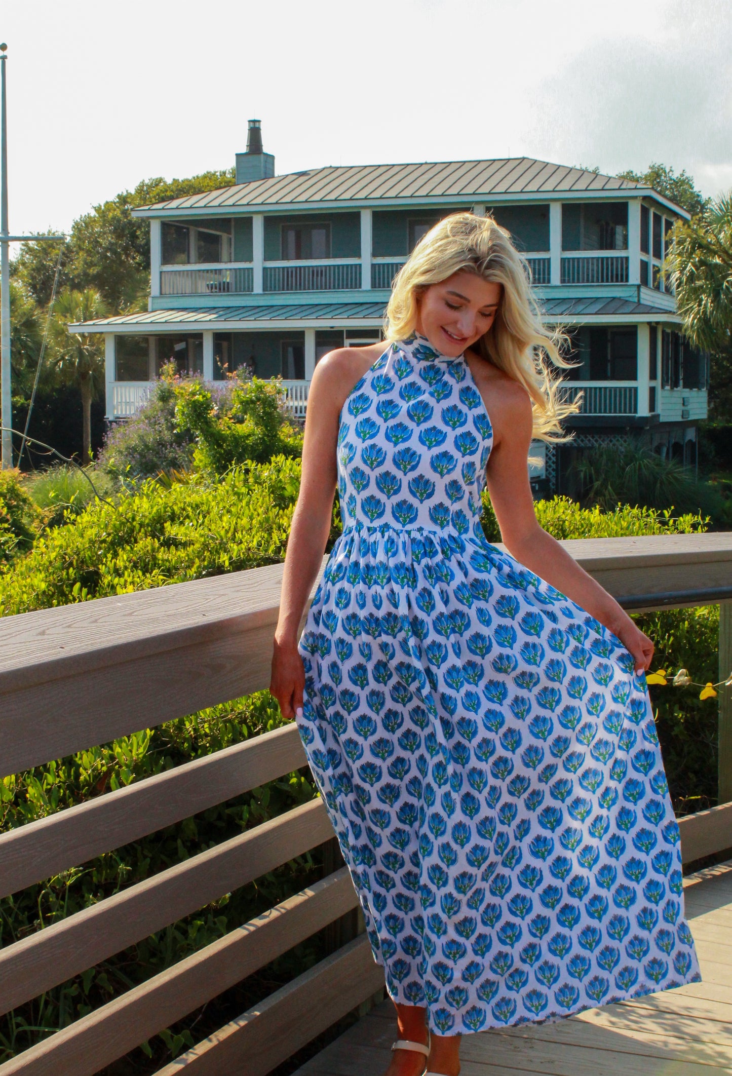Model wearing a floral print maxi dress in blue and white, perfect for summer outings.