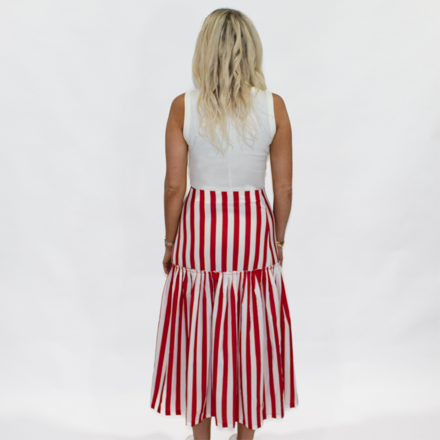 Woman wearing a red and white striped dress on a plain background