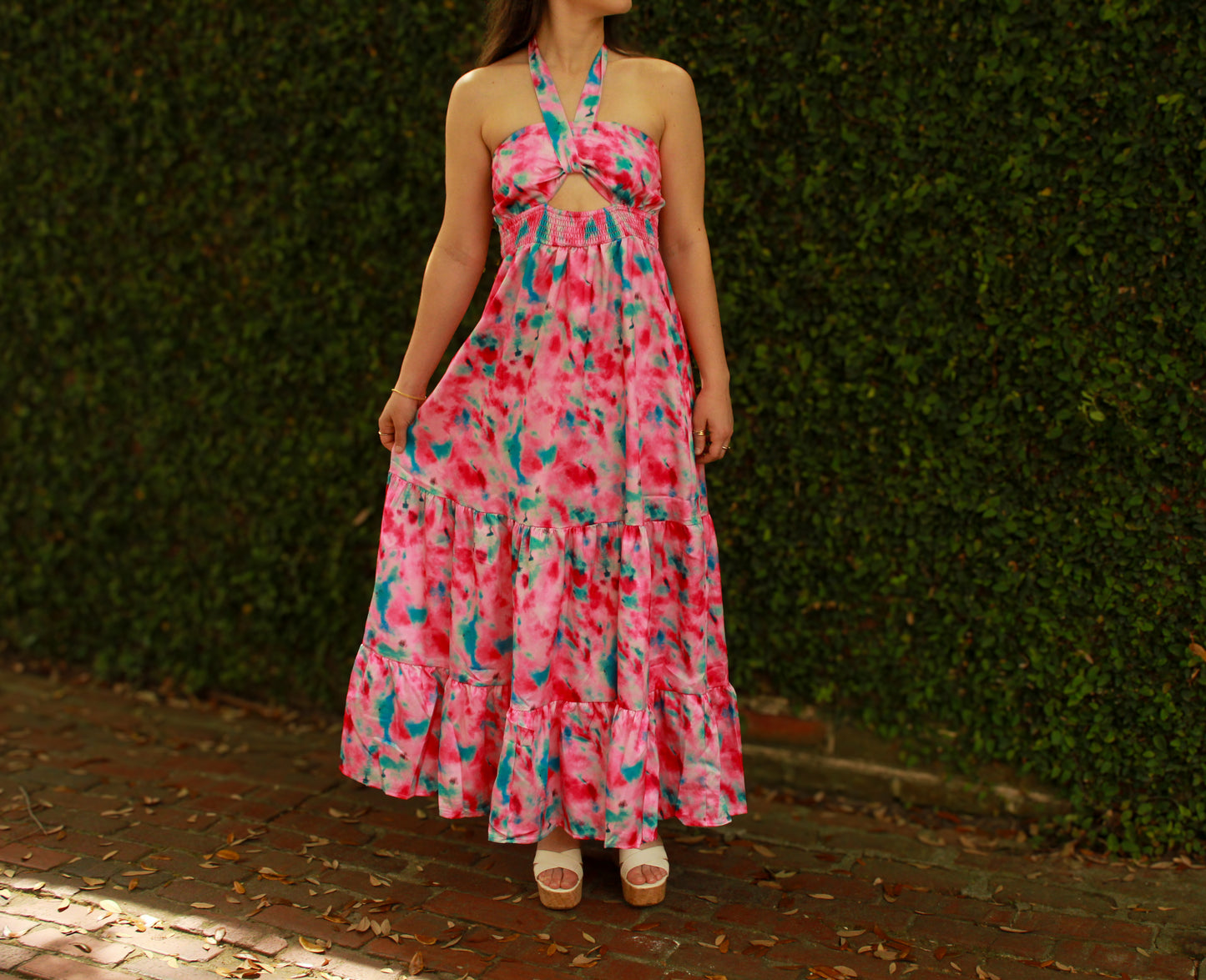 Flowy pink tie-dye maxi dress with halter neck and tiered skirt, perfect for summer outings.
