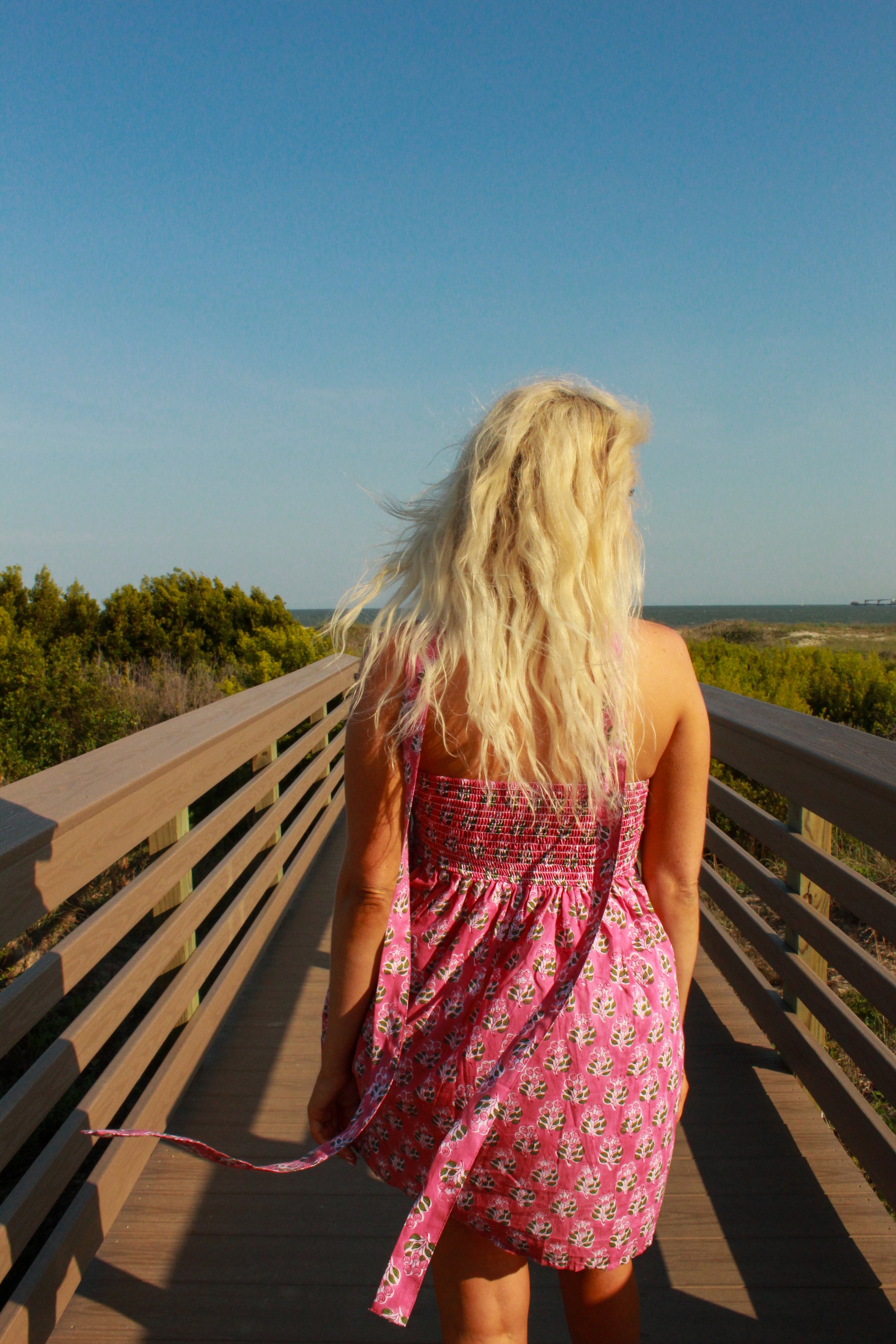 Floral pink sundress with a smocked back, perfect for summer outings and beach walks.