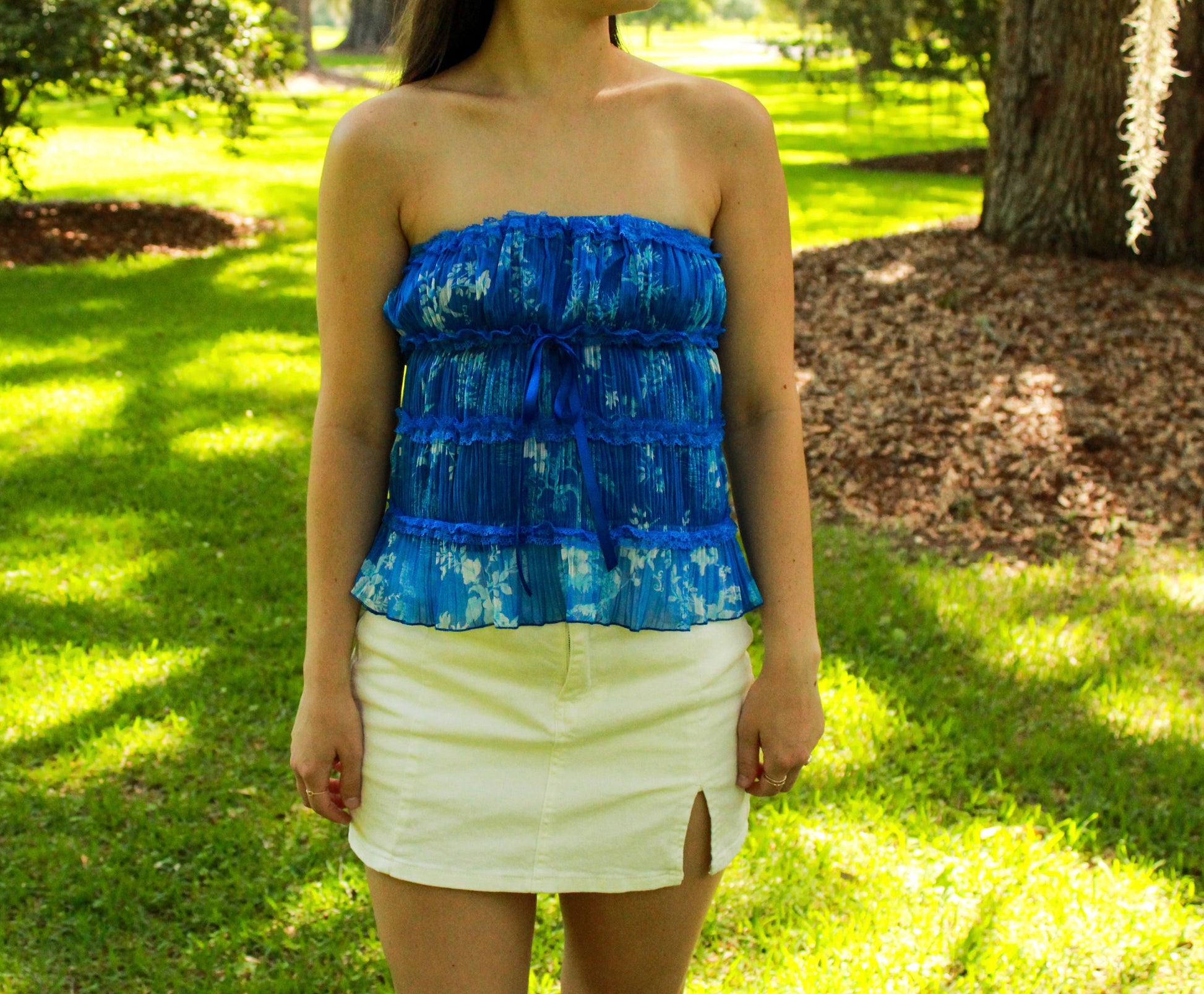 Women's blue floral strapless top, lightweight material, paired with a white skirt, perfect for summer outings.