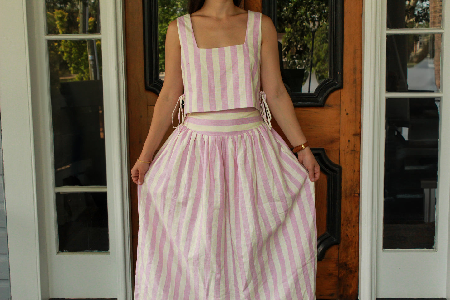 Pink and white striped women's two-piece set featuring a crop top and flowy skirt.
