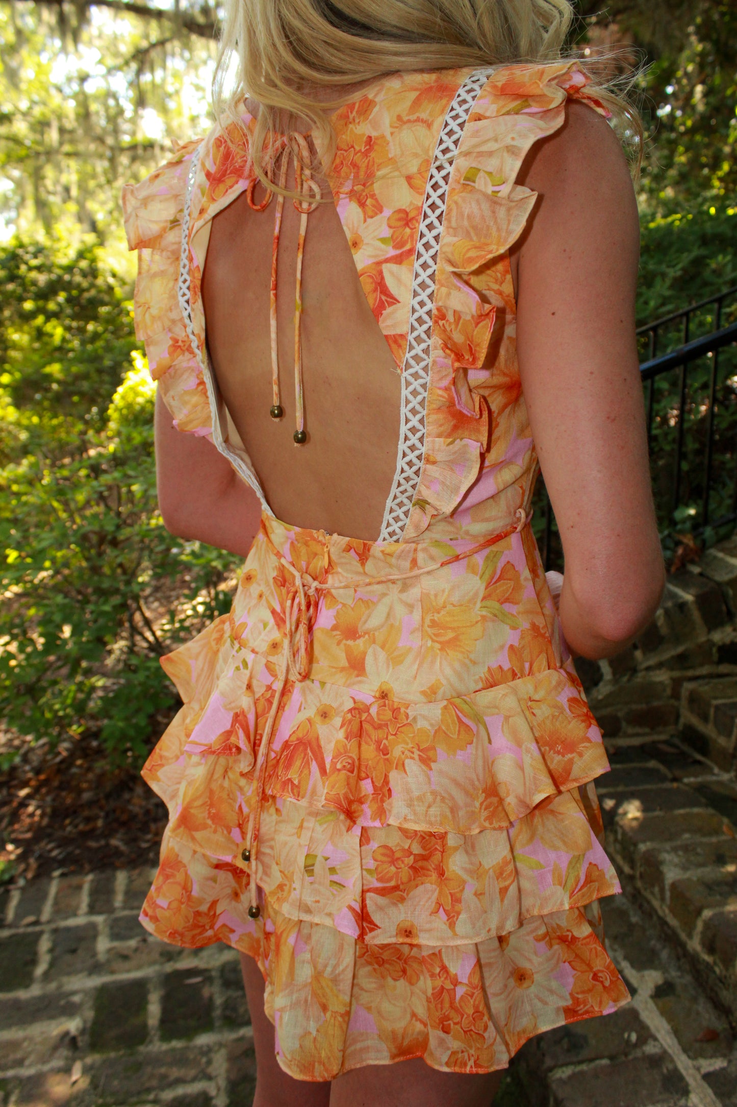 Floral orange ruffled dress with an open back and lace detailing, perfect for summer outings.