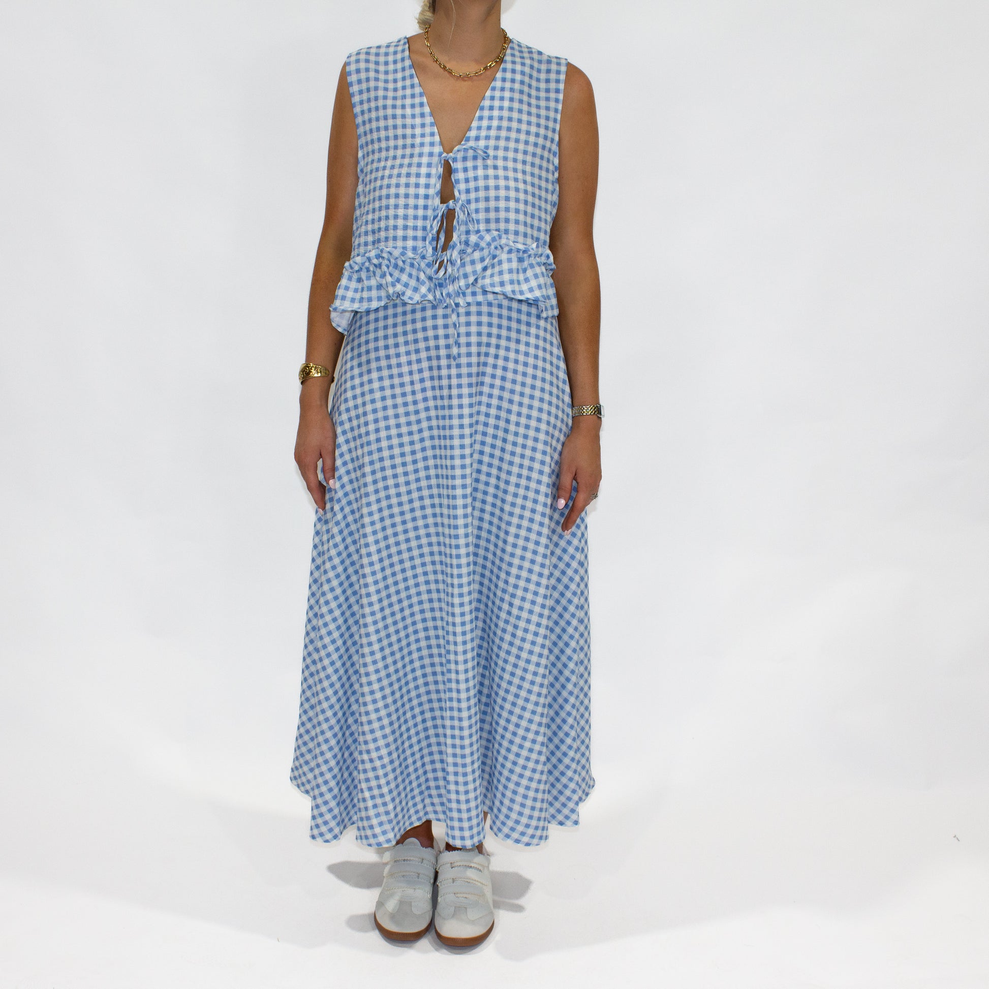 Woman wearing a blue checkered dress on a white background