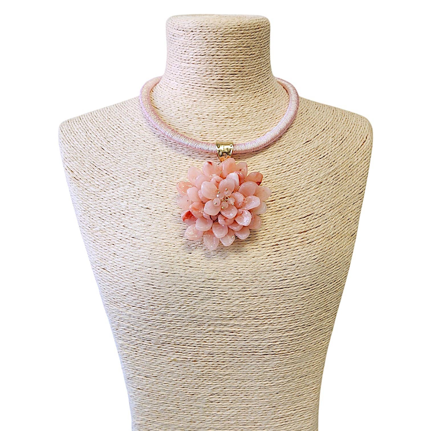 Elegant pink flower pendant necklace on a display, featuring a soft fabric cord and sparkling details.