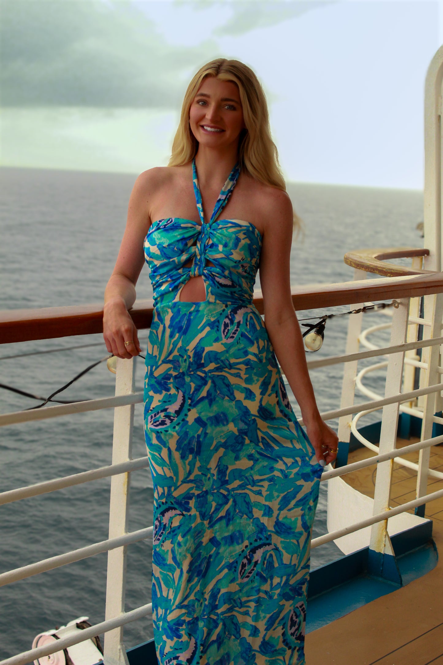 Stylish blue floral maxi dress with halter neck and cut-out detail, perfect for beach outings.
