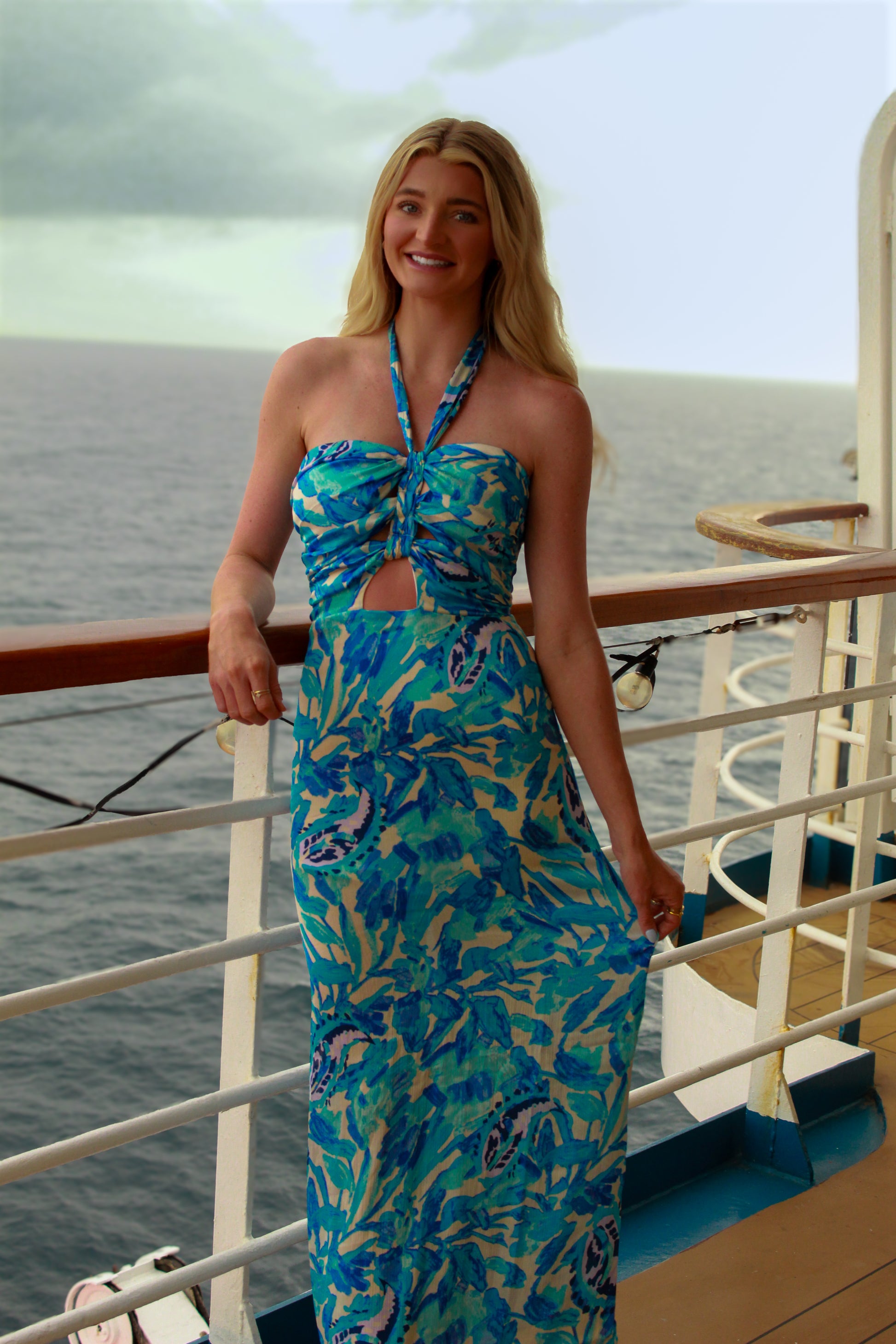 Stylish blue floral maxi dress with halter neck and cut-out detail, perfect for beach outings.