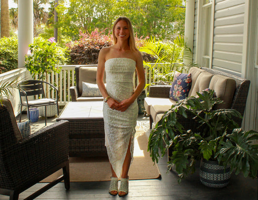 Elegant strapless white lace dress with a thigh-high slit, perfect for summer occasions.