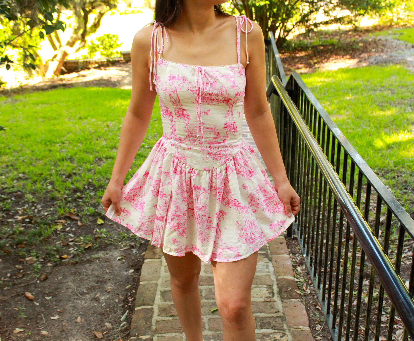 Floral pink and cream sundress with adjustable straps and a flared skirt, perfect for summer outings.