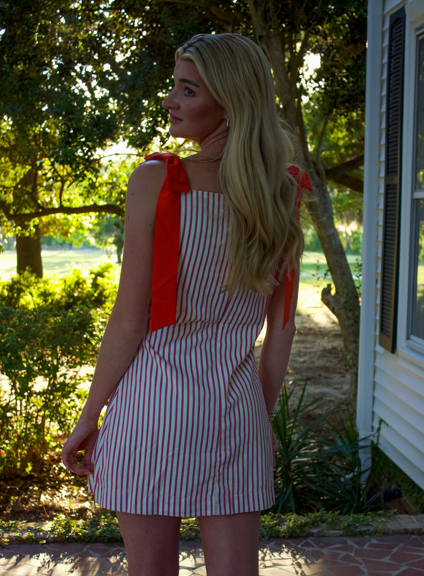 Chic striped mini dress with red ruffle sleeves, perfect for summer outings.