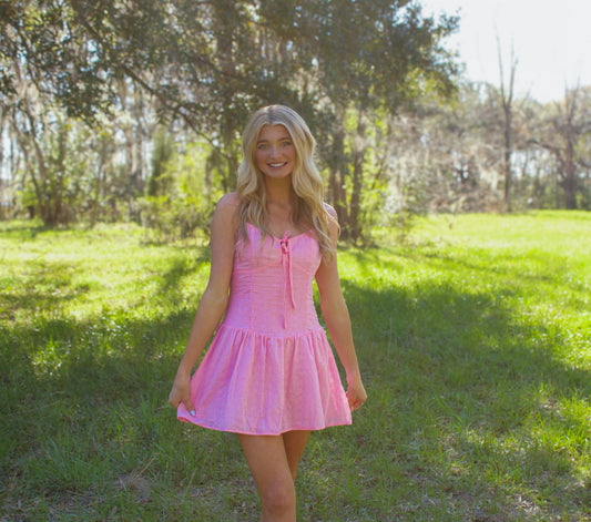 Light pink summer dress with adjustable tie, fitted bodice, and flared skirt, perfect for sunny outings.