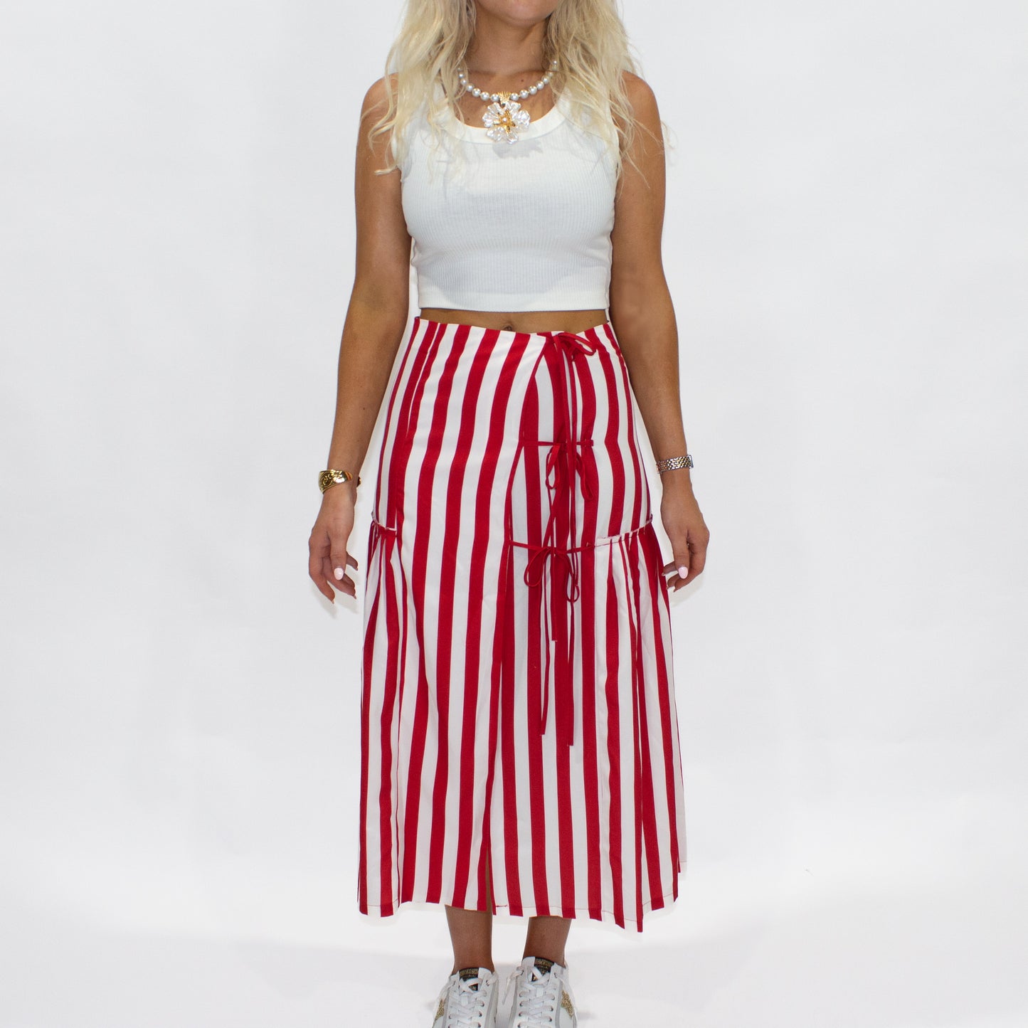 Person wearing a white top and red and white striped skirt on a white background