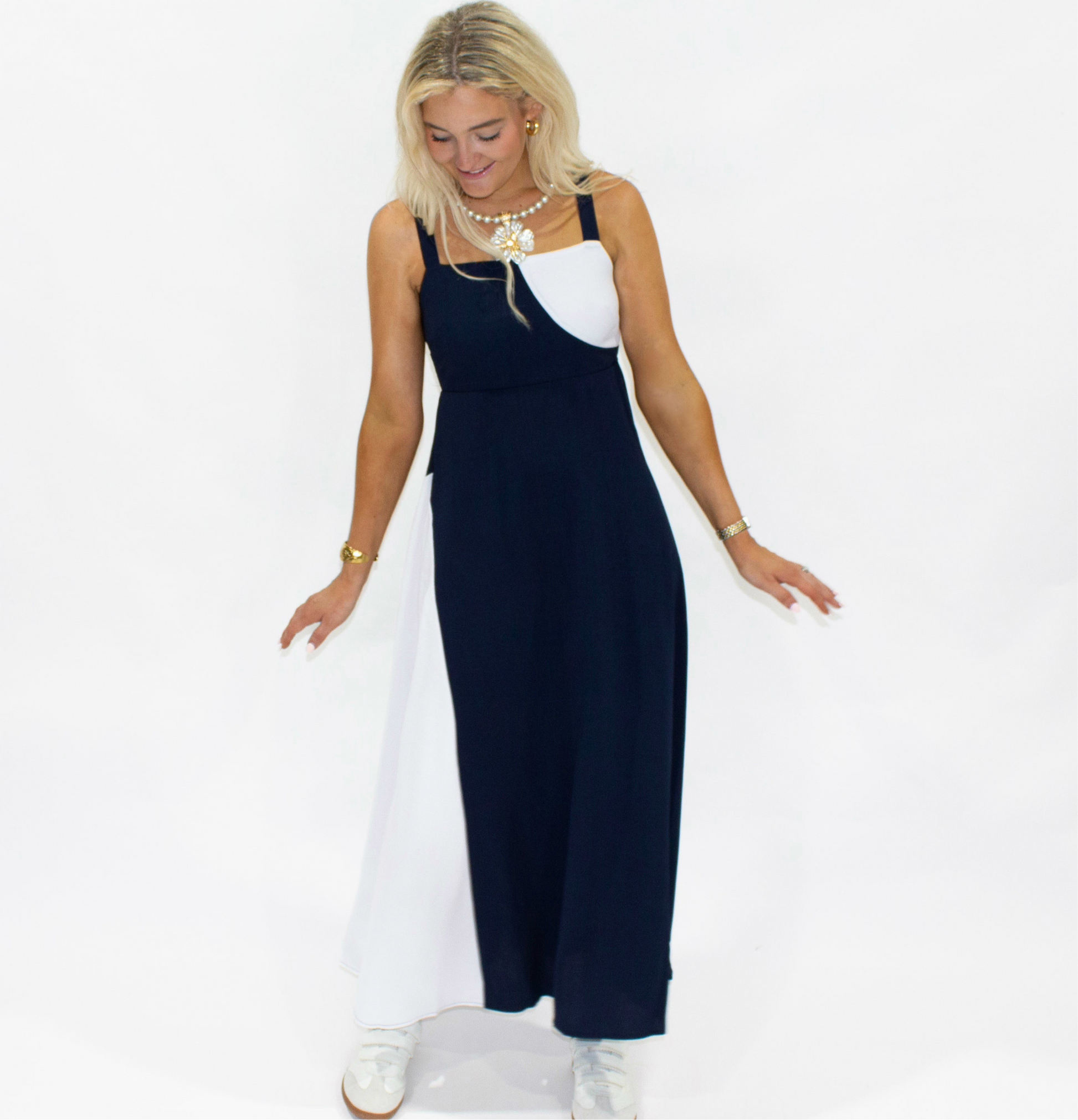 Woman wearing a navy and white dress on a plain background