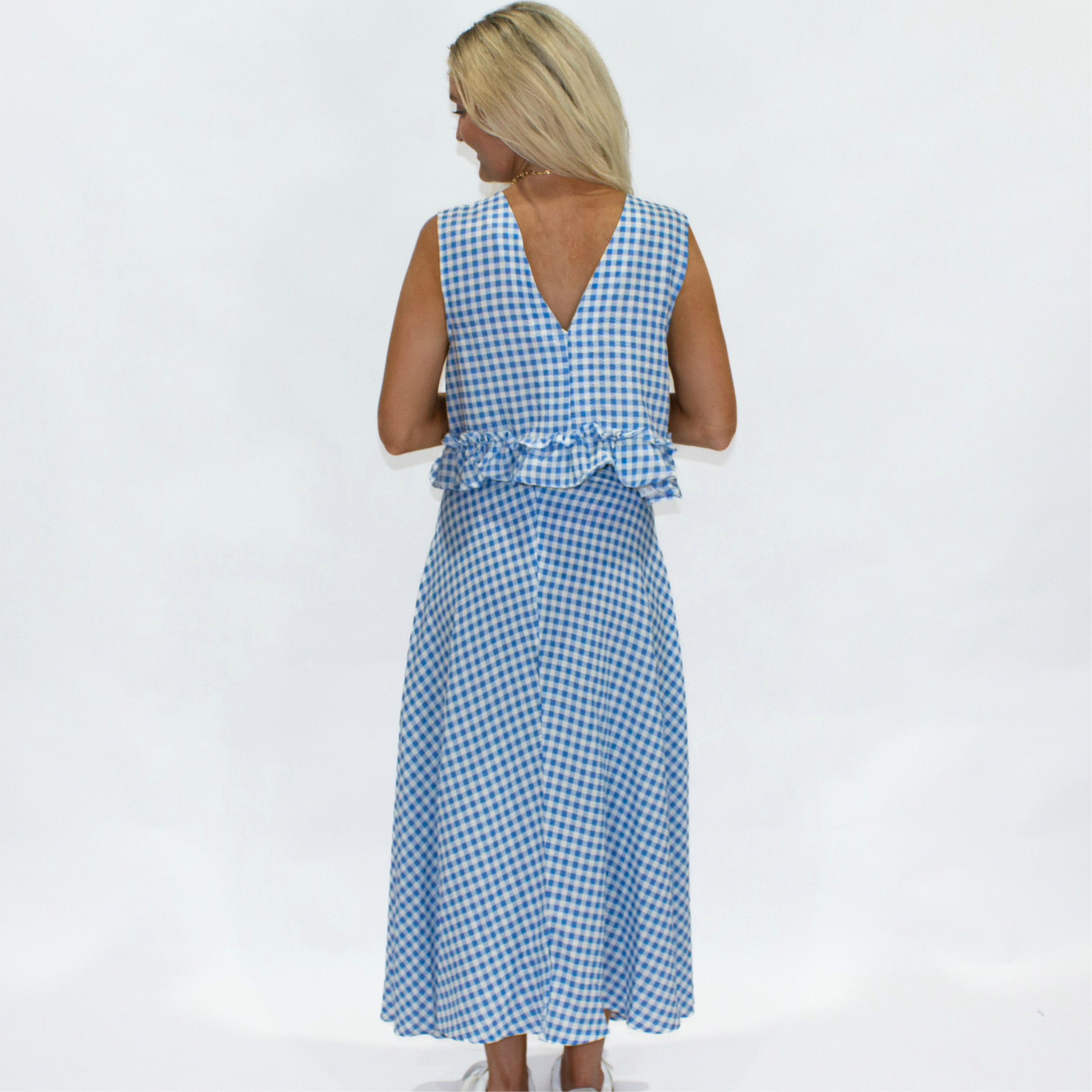 Woman wearing a blue and white checkered dress on a white background