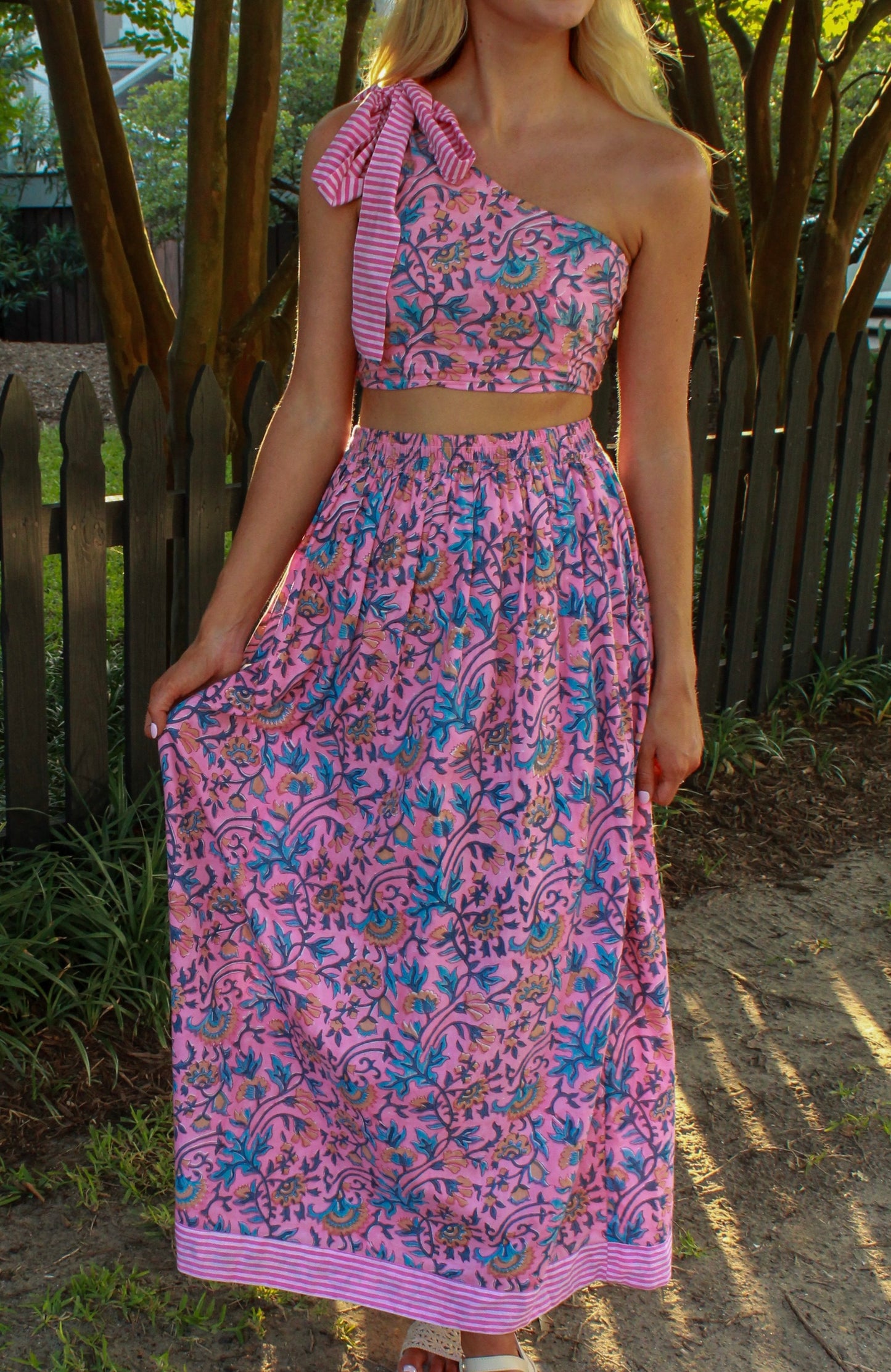 One-shoulder pink floral maxi dress with striped bow, perfect for summer outings.