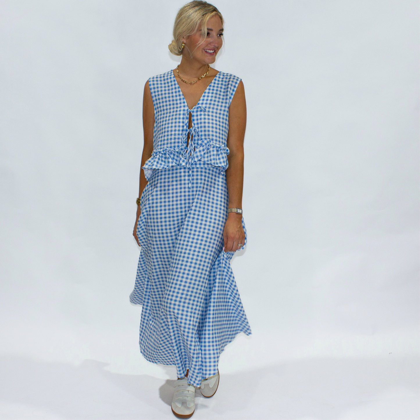 Woman wearing a blue and white checkered dress on a white background