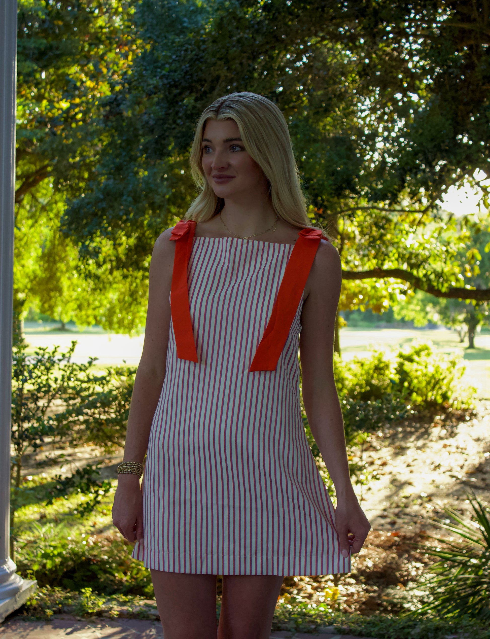 Women’s striped mini dress with orange bows, lightweight cotton fabric, perfect for summer outings.