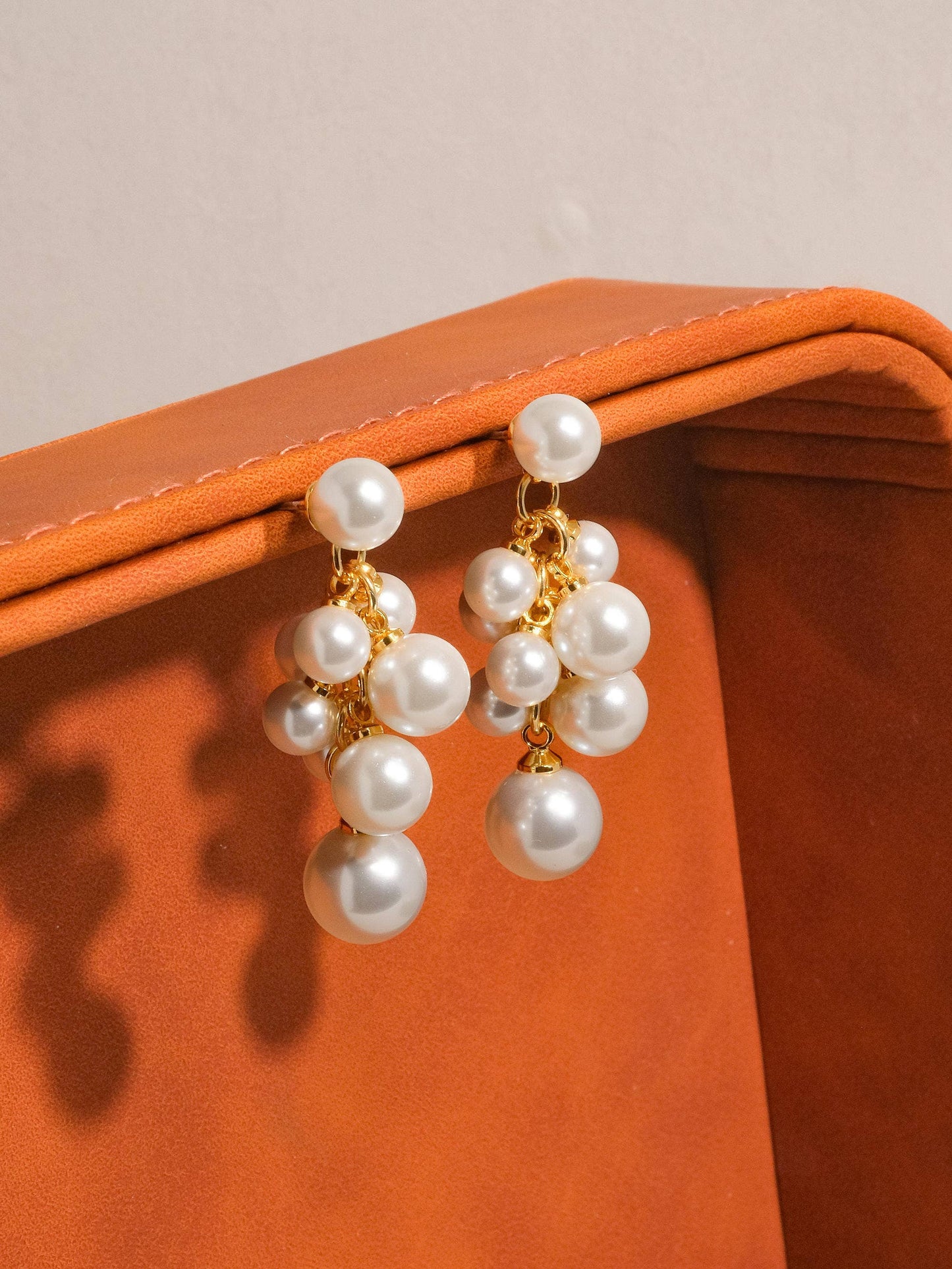 Elegant gold hoop earrings with clustered white pearls, perfect for any occasion.