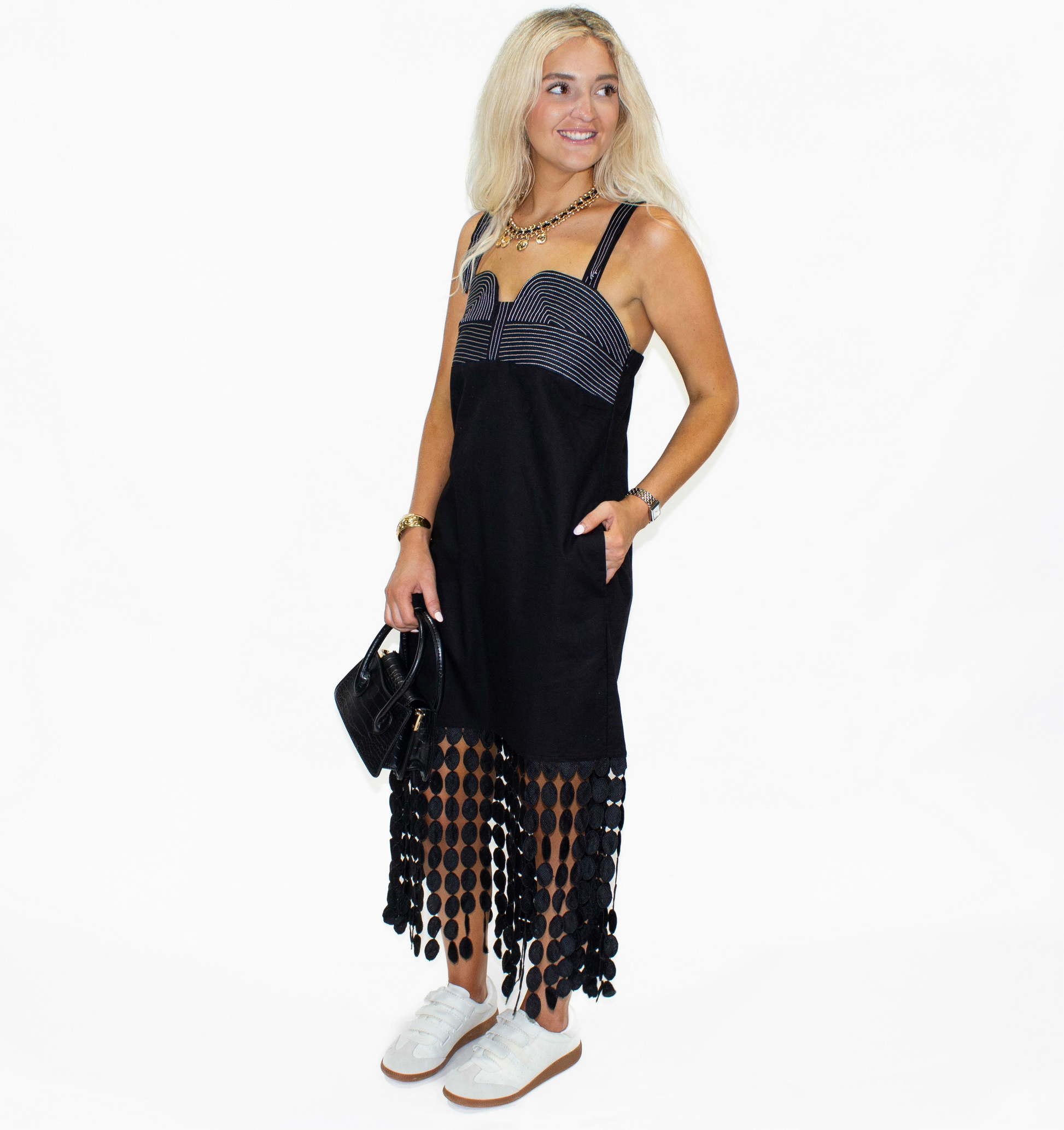 Woman wearing a black dress with sheer sides on a white background