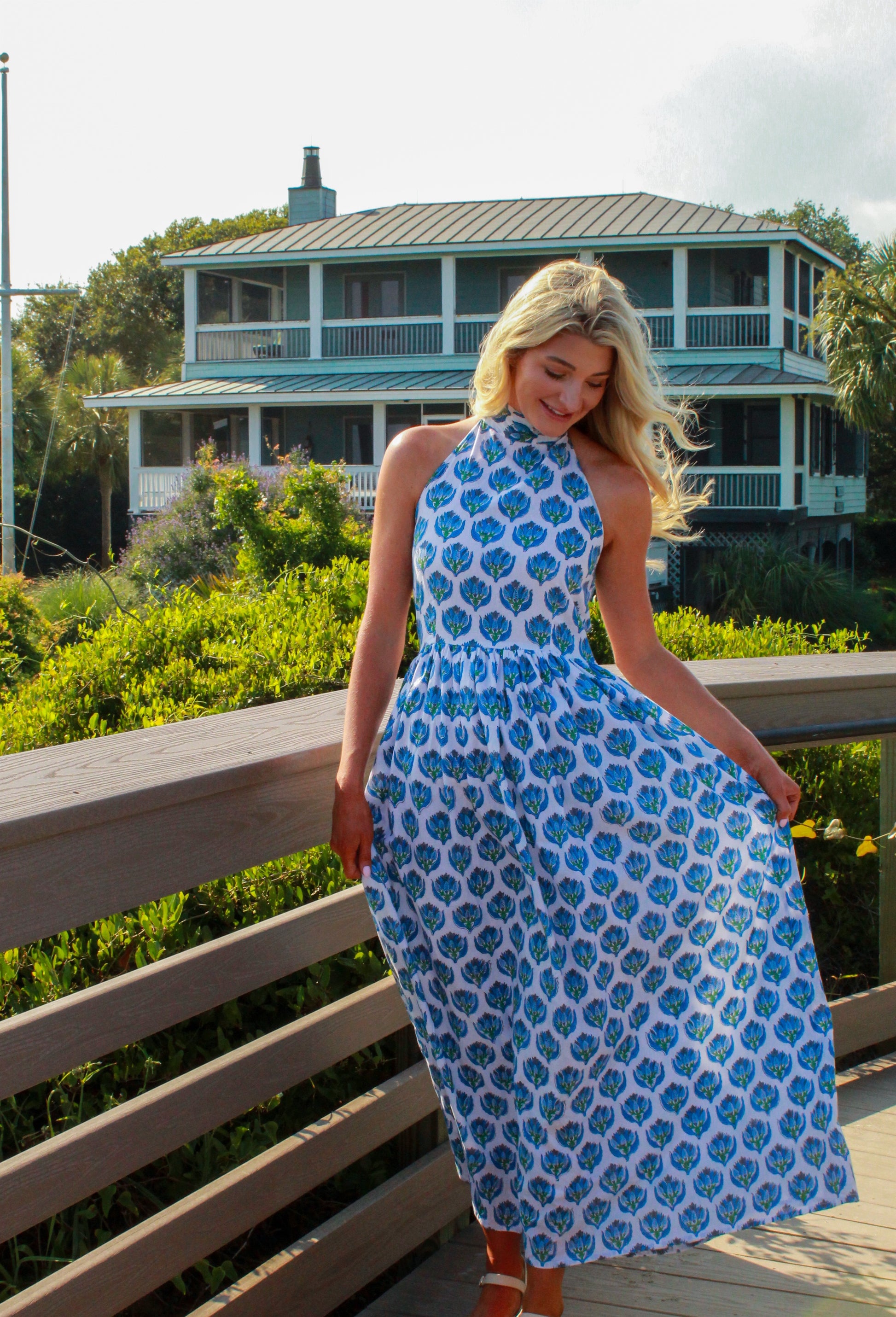 Model wearing a floral print maxi dress in blue and white, perfect for summer outings.