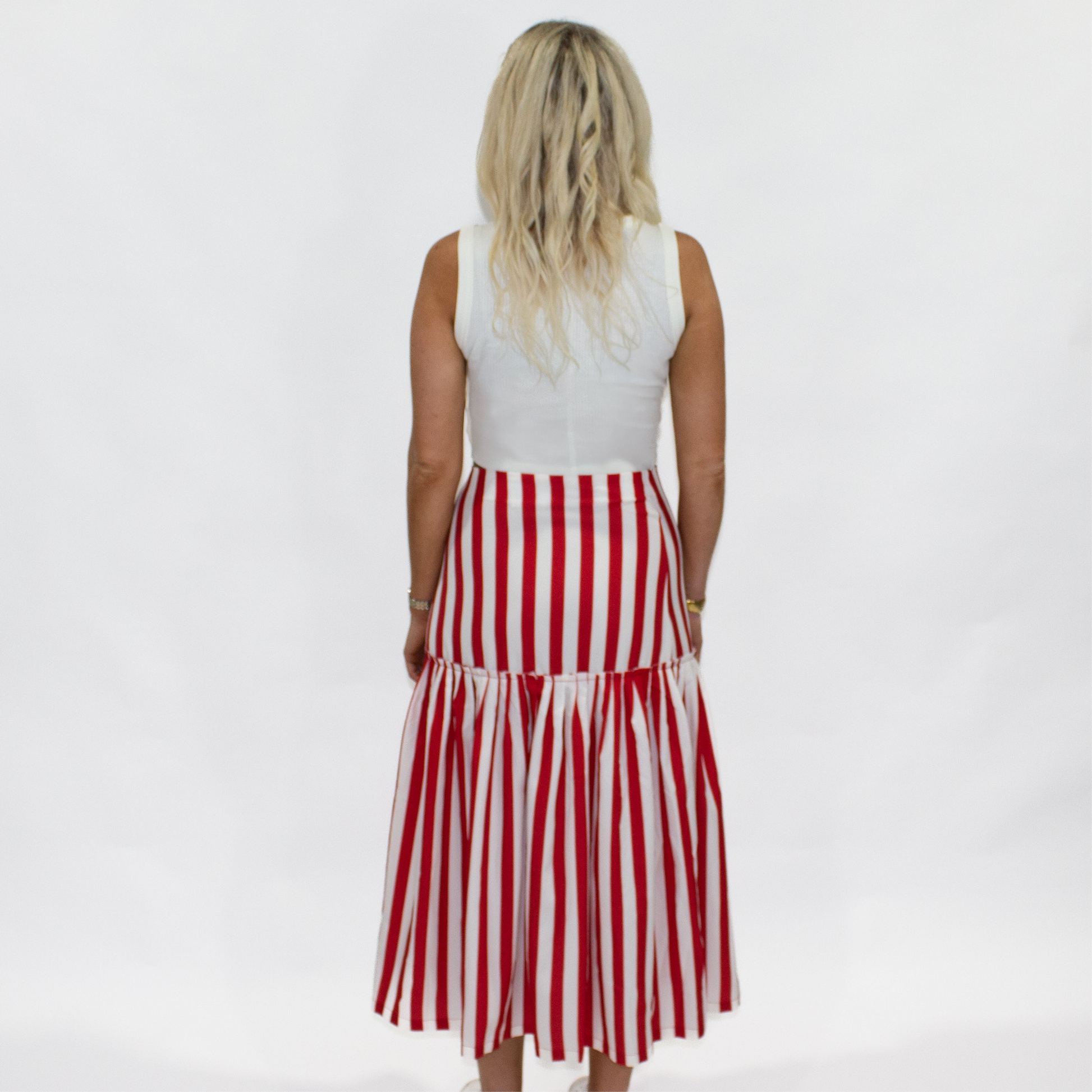 Woman wearing a red and white striped dress on a plain background