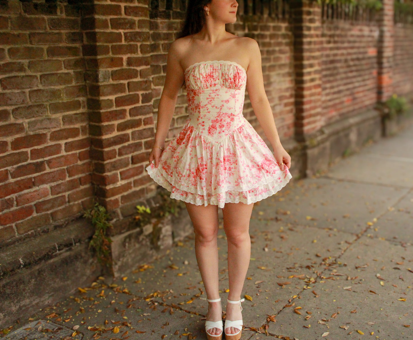 Strapless floral mini dress in cream and pink, featuring a pleated bodice and flared skirt.