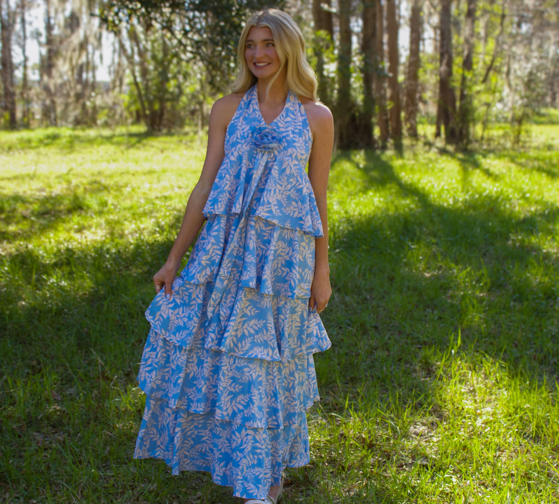 Light blue tiered maxi dress with floral print and halter neck, perfect for summer occasions.