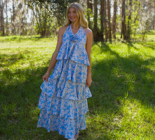 Light blue tiered maxi dress with floral print and halter neck, perfect for summer occasions.
