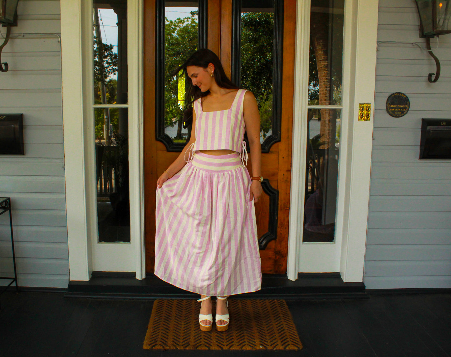 Women's pink and white striped two-piece set, featuring a cropped top and flowy skirt, perfect for summer outings.