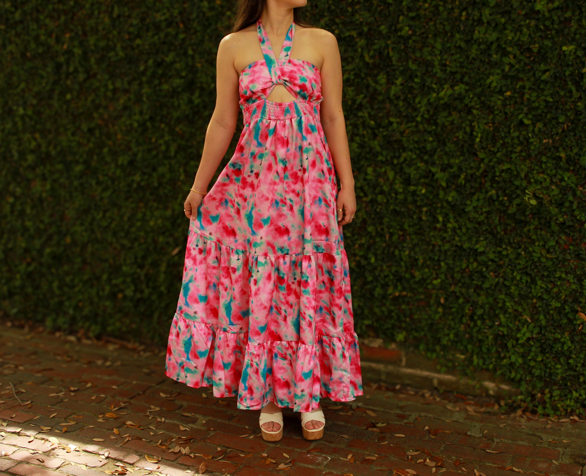 Flowy pink tie-dye maxi dress with halter neck and tiered skirt, perfect for summer outings.