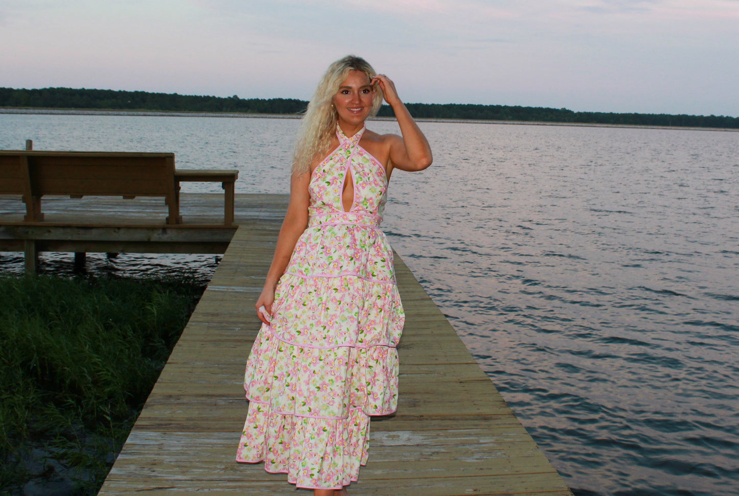 Floral pink maxi dress with halter neck and tiered design, perfect for summer outings by the water.