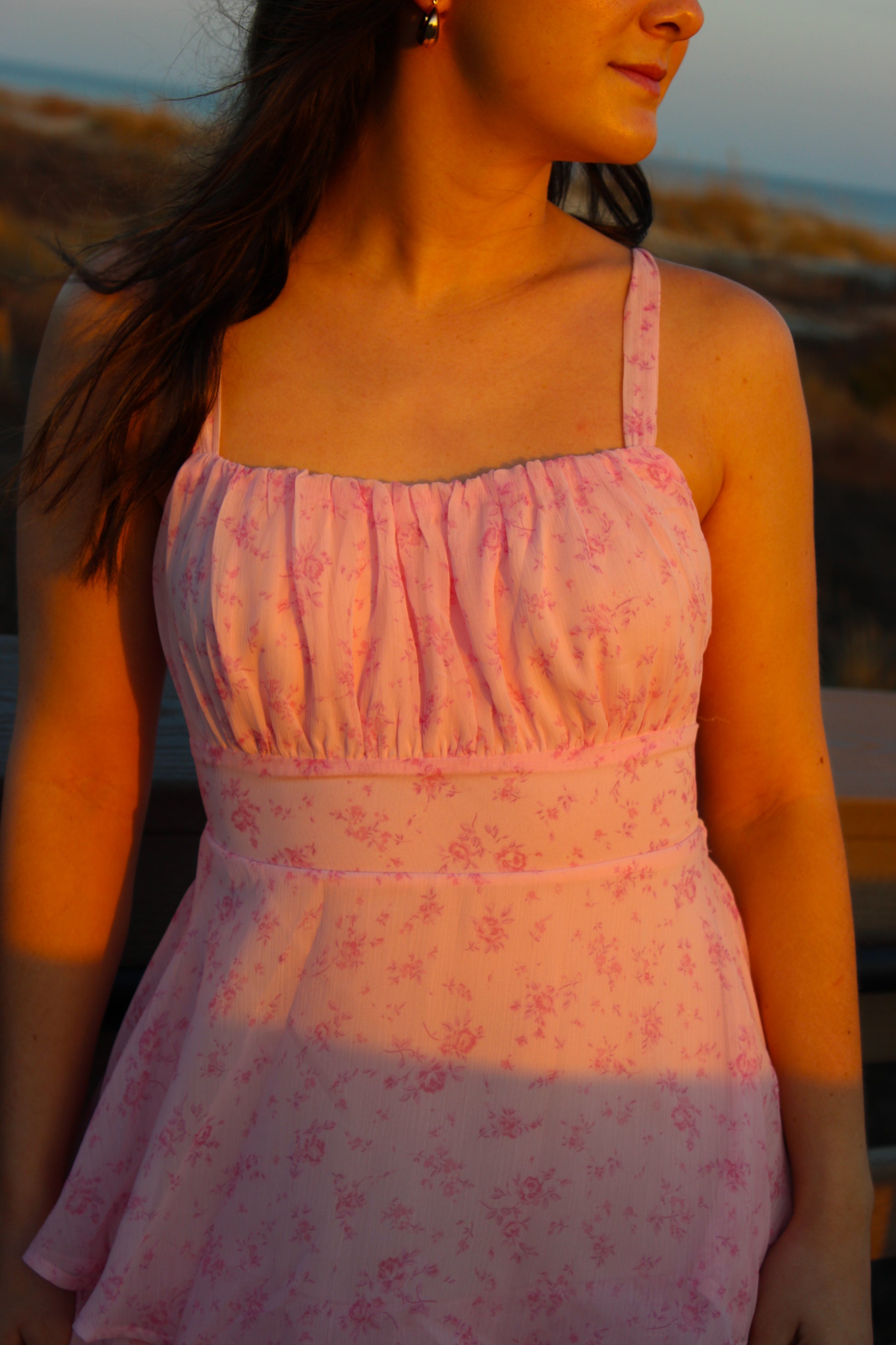 Light pink floral dress with ruched bodice and adjustable straps, perfect for summer outings.