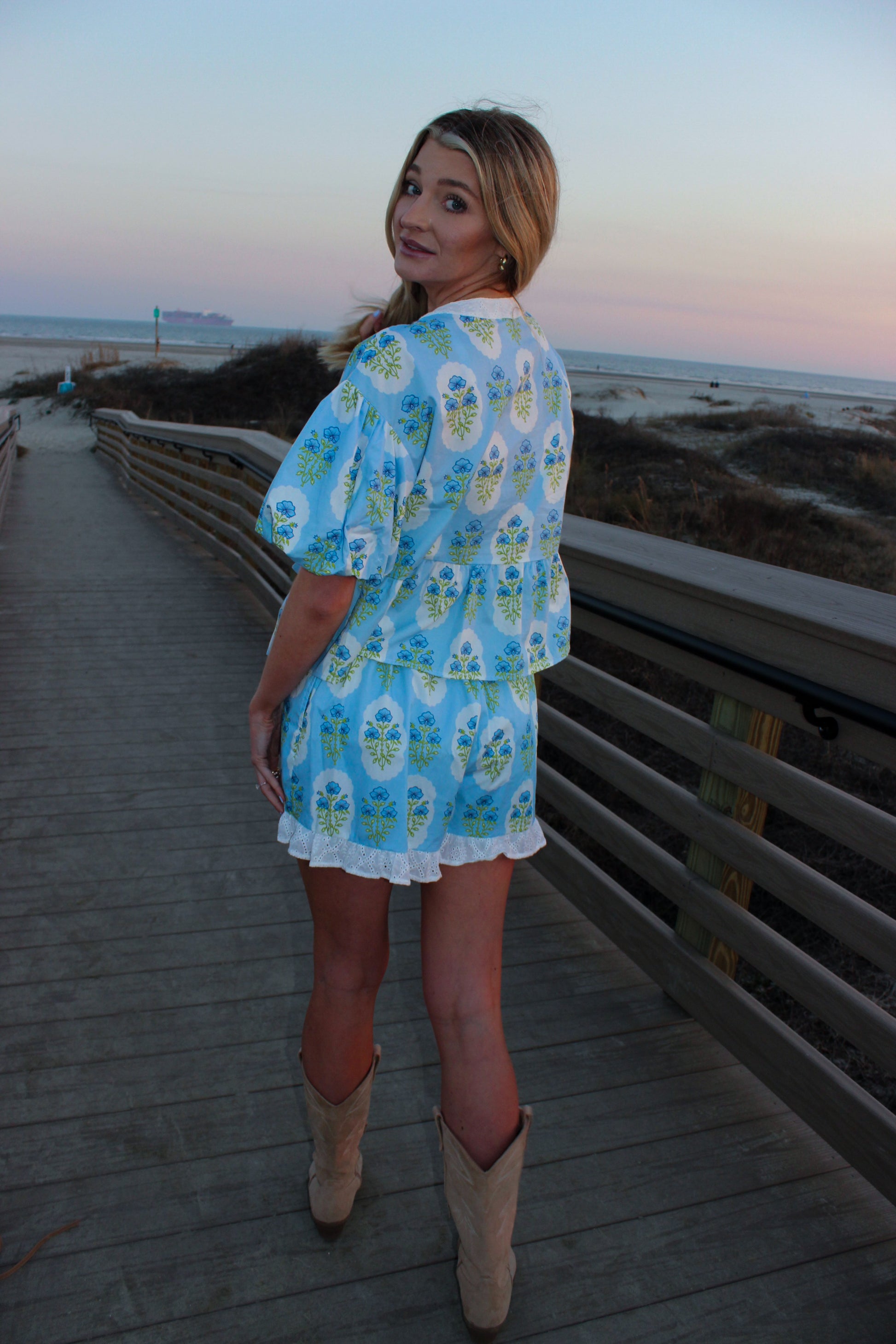 Light blue floral print two-piece set with ruffled sleeves and shorts, perfect for beach outings.