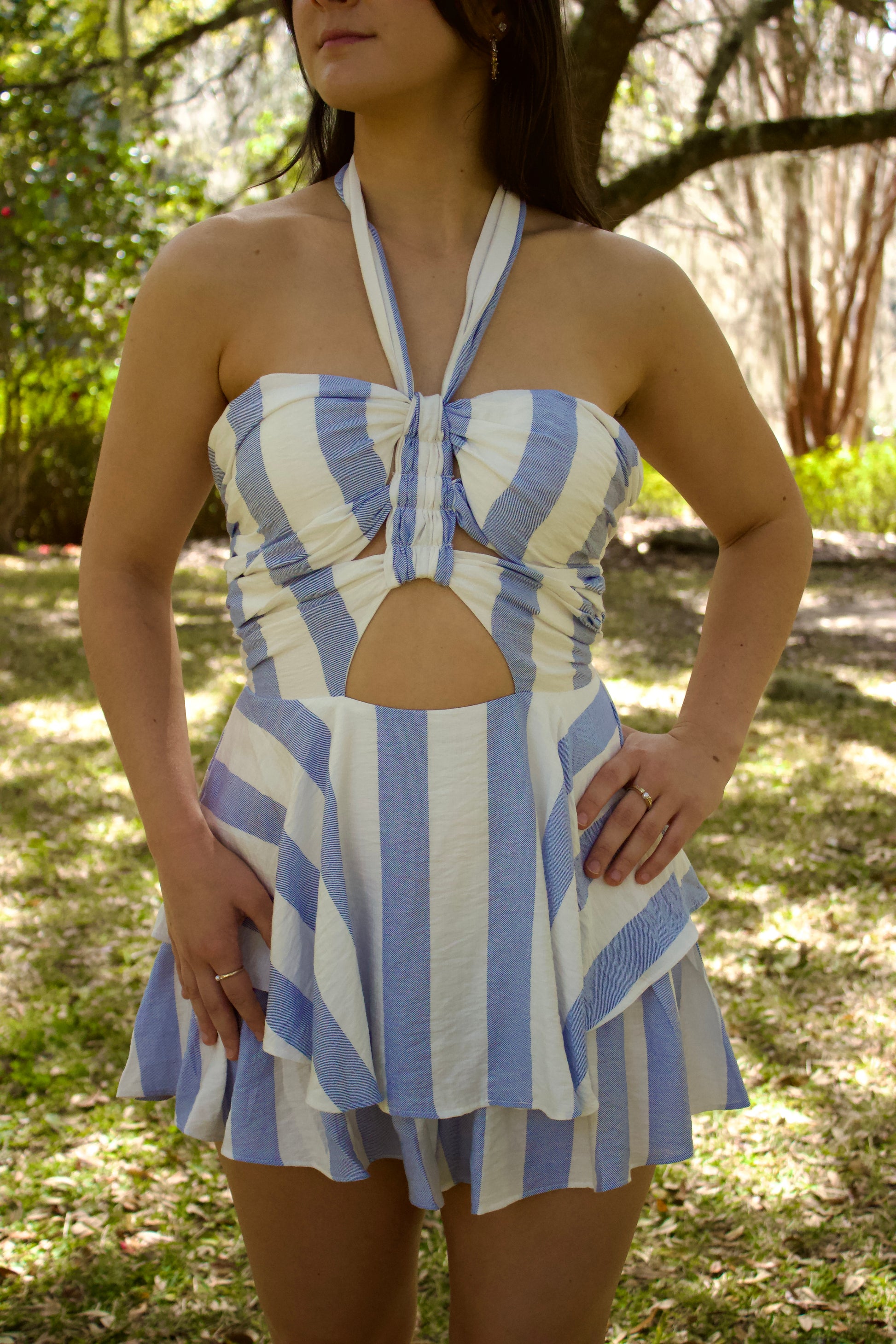 Women's halter neck striped dress in blue and white, featuring a cutout design and flared skirt.