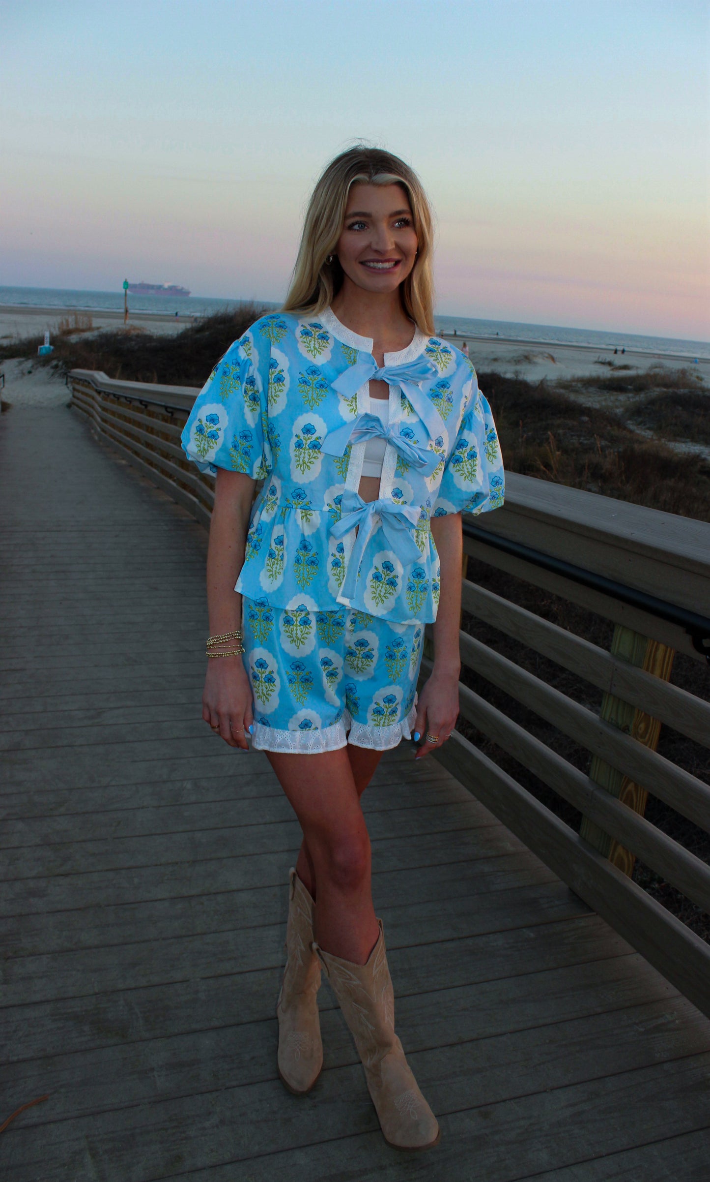 Blue floral two-piece outfit with bows, featuring a peplum top and shorts, perfect for summer outings.