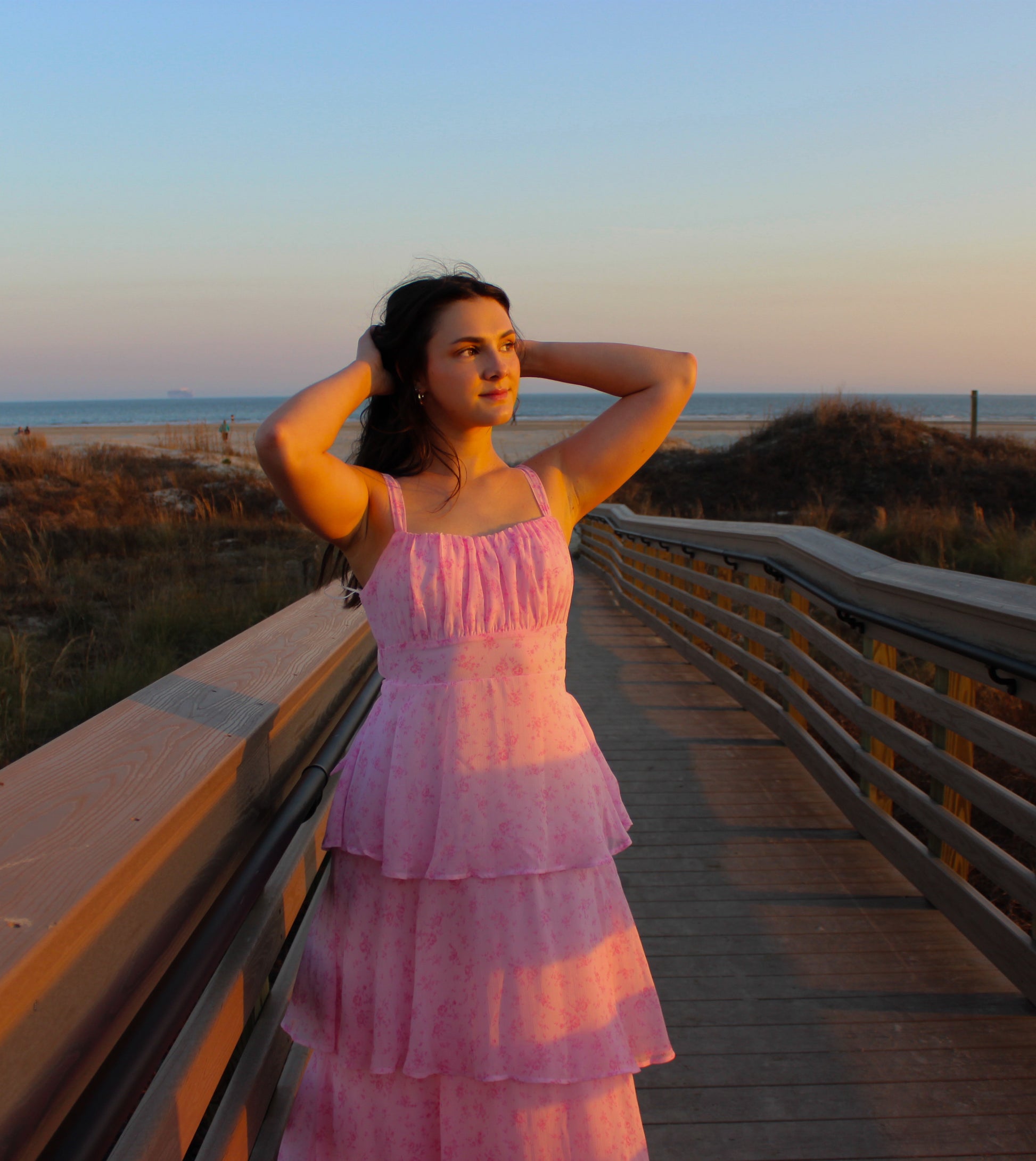 Pink tiered summer dress with floral print, perfect for beach outings and warm evenings.