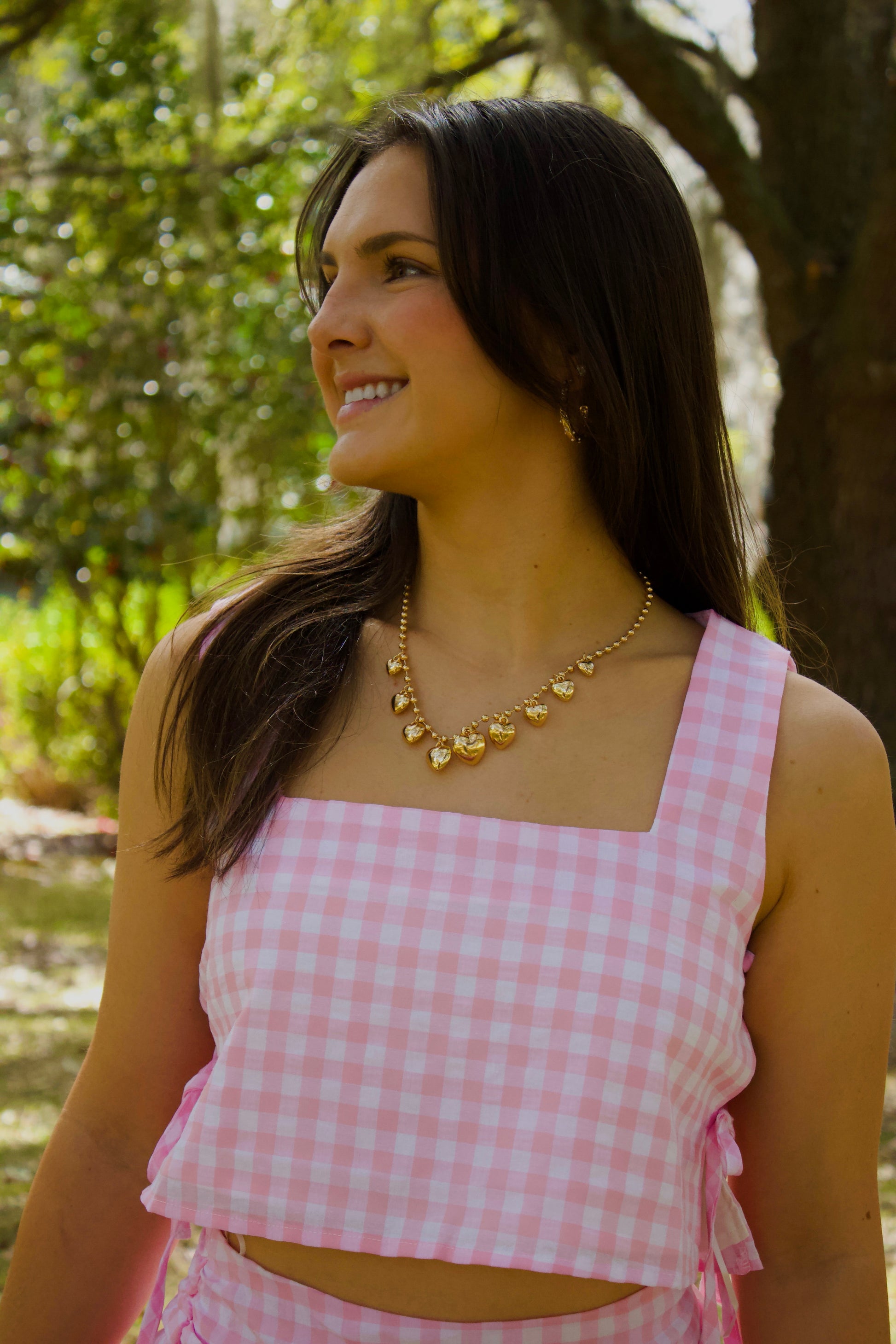 Pink gingham crop top with square neckline and ribbon ties, perfect for summer fashion.