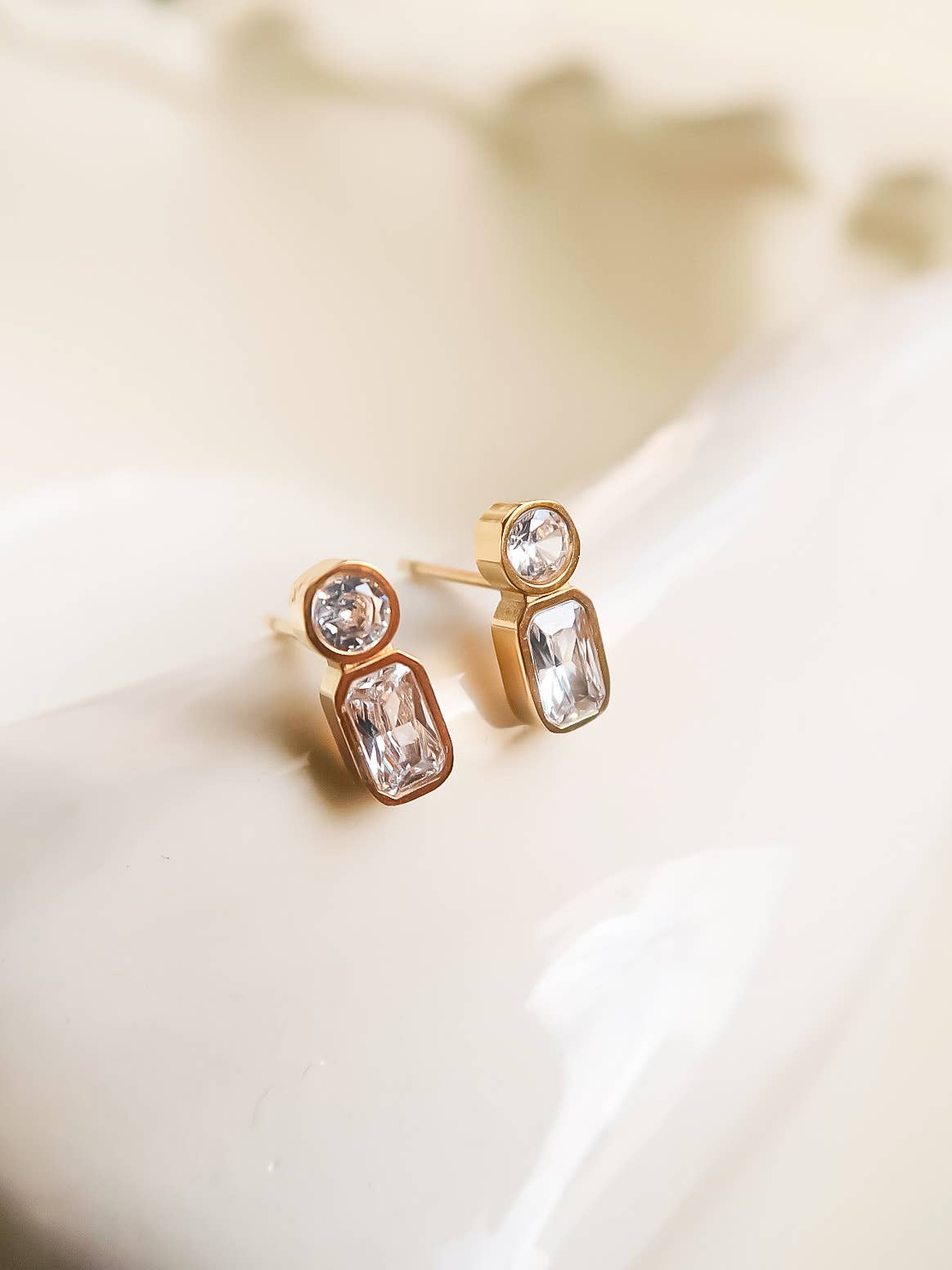 Elegant gold stud earrings featuring clear crystal gemstones, perfect for sophisticated accessorizing.