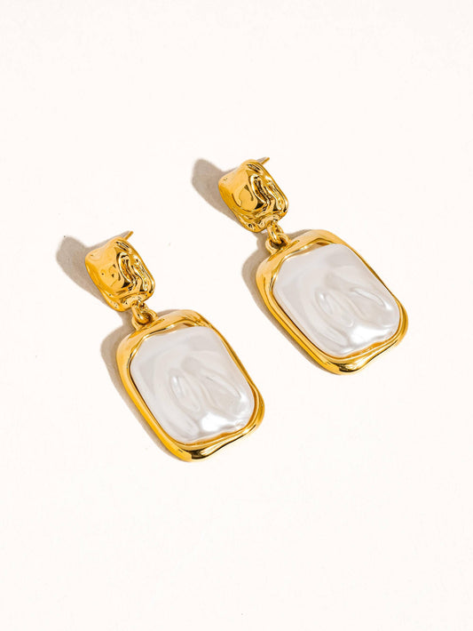 Gold drop earrings with a glossy white resin centerpiece, perfect for elegant occasions.