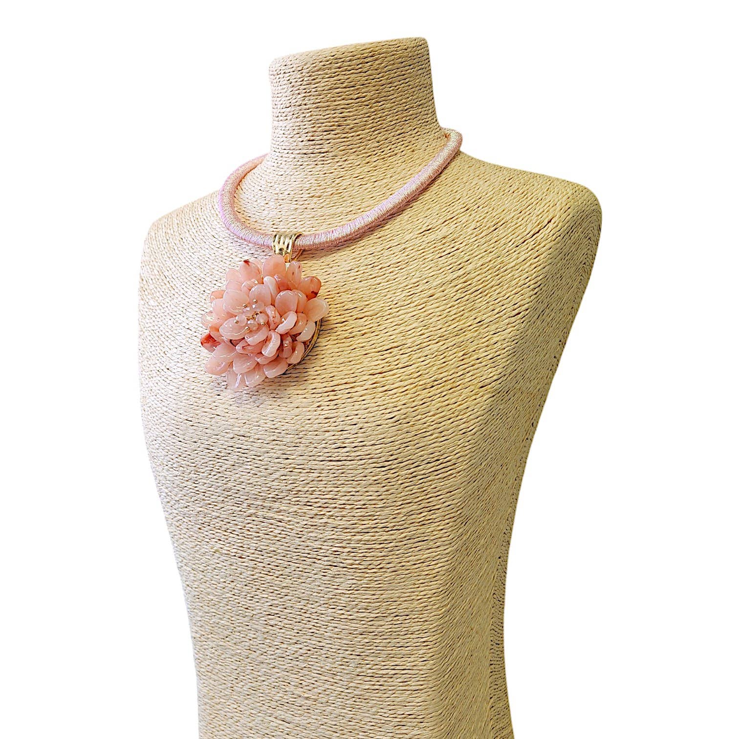 Handmade pink flower pendant necklace on a textured display bust.