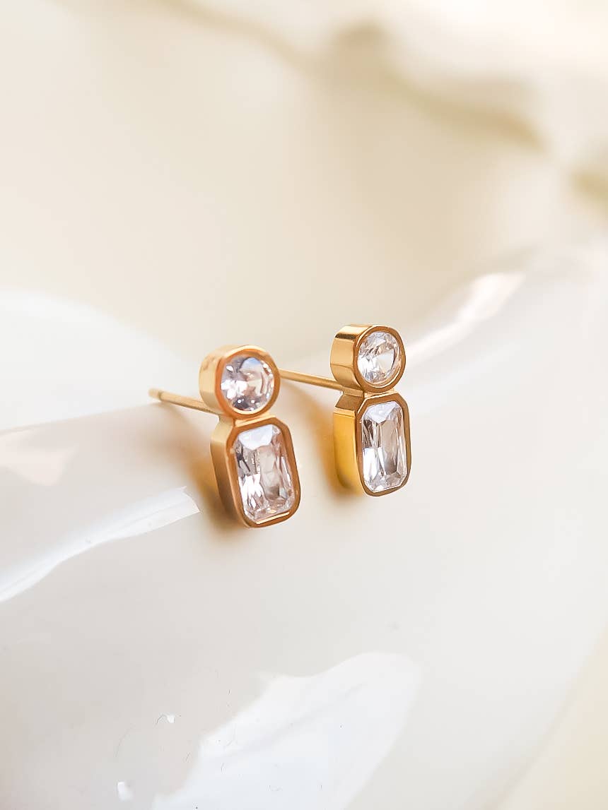 Elegant gold stud earrings featuring round and rectangular clear crystals.